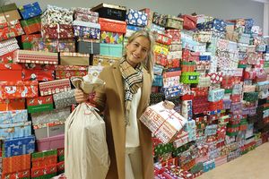 Eine Mitarbeiterin vom CJD Erfurt mit vielen Geschenk-Kartons.