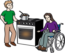Mann und Frau im Rollstuhl kochen am Herd